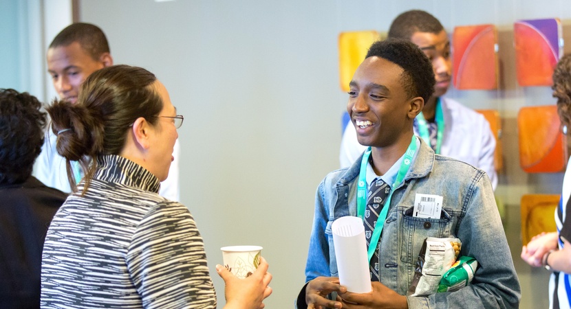 Devaughn Branch-el, a scholar from Eagle Academy, practices his networking skills with Astrid Tsang (left), Vice President and Assistant General Counsel at LPL Financial. (Photo by Jay Haas)